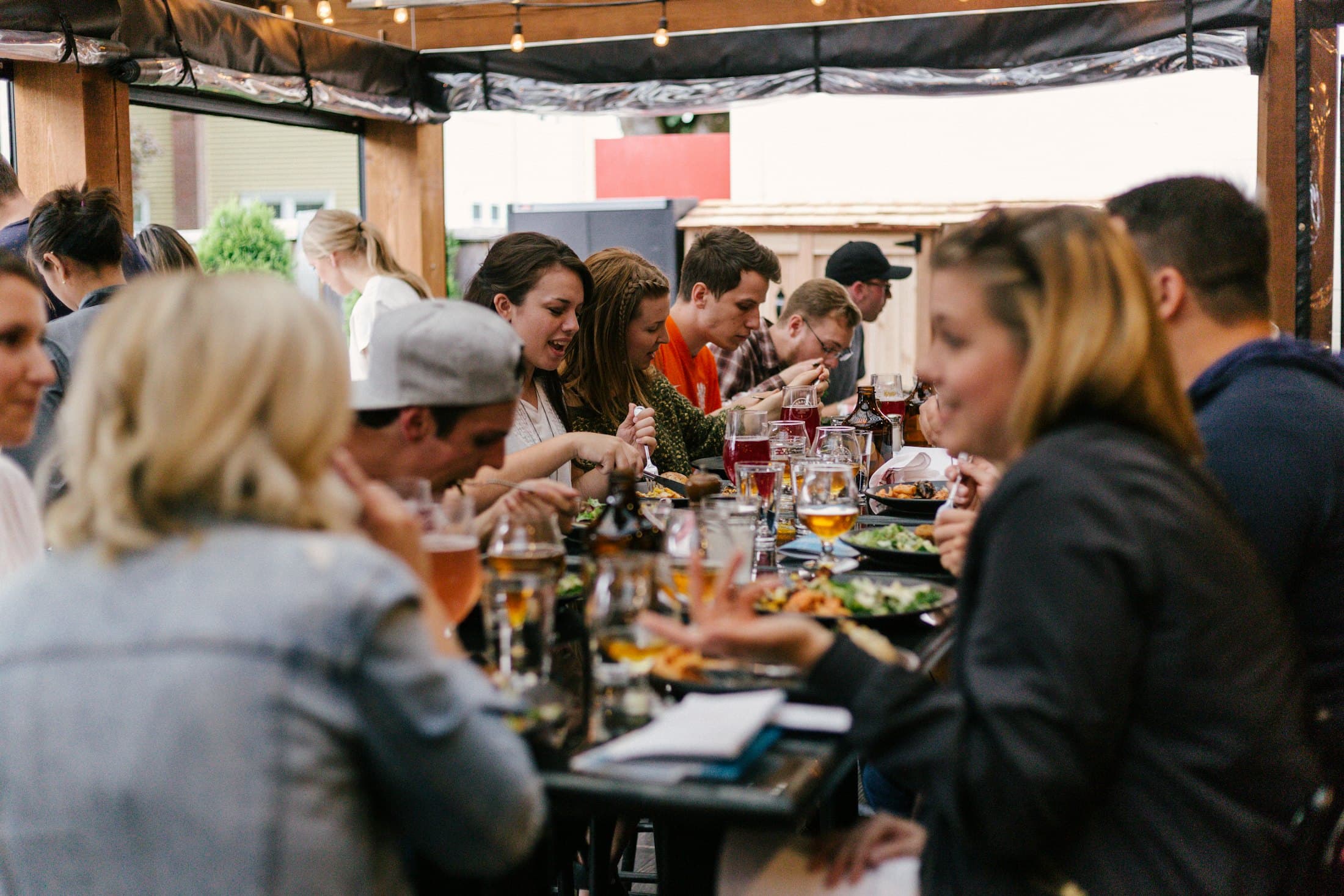 Friends laughing together around a long dinner table